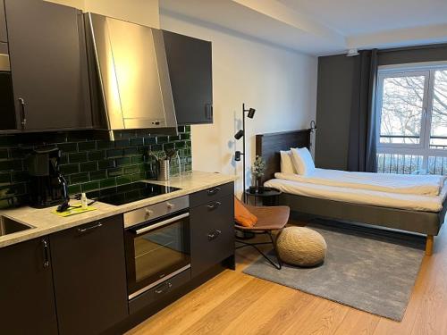 a room with a kitchen with a bed in it at Magnolia House Norrviken in Sollentuna