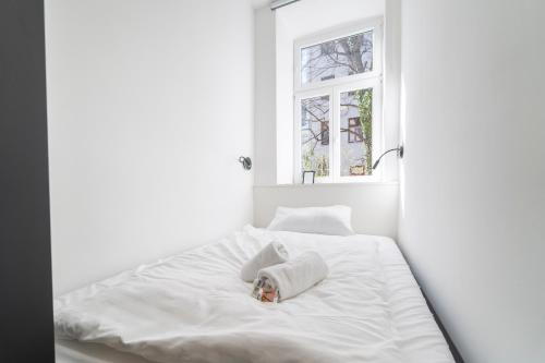Cama blanca en habitación blanca con ventana en Minimus I levestate, en Viena