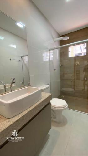a bathroom with a white sink and a toilet at Residencial Rocha - Praia de Guaratiba - Prado - Ba in Prado