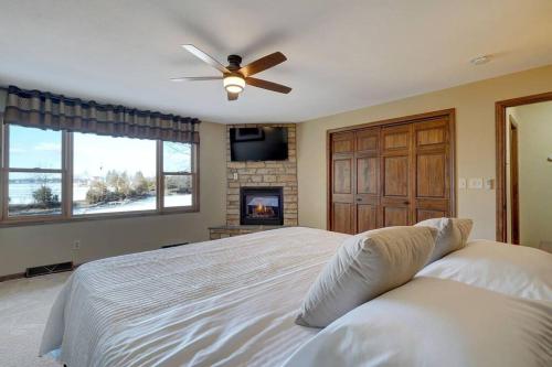 1 dormitorio con 1 cama con ventilador de techo y chimenea en Bayside Beach House, en Burlington