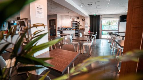 a restaurant with tables and chairs and a counter at Kyriad Saint Brieuc - Tregueux in Tregueux