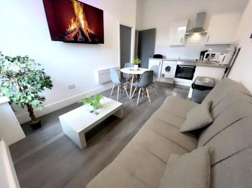 Albert Luxury Hottub & Jacuzzi Apartments في بلاكبول: غرفة معيشة مع أريكة وطاولة