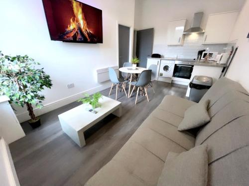 a living room with a couch and a table at Albert Hottub & Jacuzzi Apartments in Blackpool