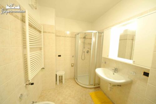 biała łazienka z prysznicem i umywalką w obiekcie Appartamento MilHouse by Livigno Accomodation w Livigno