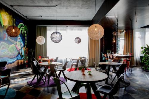 a restaurant with tables and chairs and a large window at P182 Hidden Hostel in Berlin