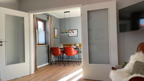 a hallway with a dining room with red chairs at Das Bergquartier - Ferienwohnung Zugspitze in Oberau