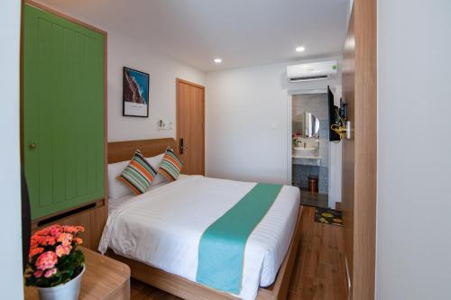 a bedroom with a bed and a green door at The View Hotel in Cam Lâm