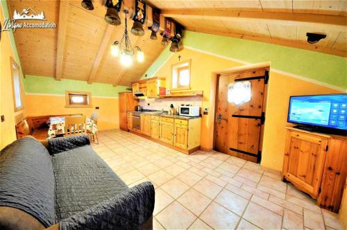a living room with a couch and a flat screen tv at Baita Hanzel e Gretel in Livigno
