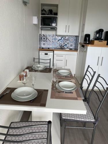 een keuken met een tafel met twee stoelen en een tafel en een stoeltje bij ESCAPADE FAMILIALE A LA MER in Quiberon
