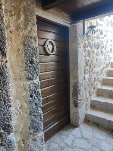 a wooden door in a stone wall with stairs at Agriturismo Le Faeta in Arpino