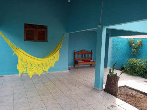 een kamer met een geel net op een blauwe muur bij Aluguel Temporada em Martins/RN in Martins