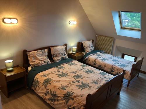 a bedroom with two beds and two lamps at Le Relais des Sites in Faverolles