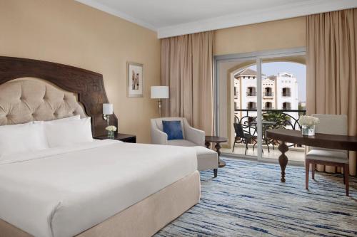 a hotel room with a bed and a desk and a window at Crowne Plaza Riyadh Al Waha by IHG in Riyadh