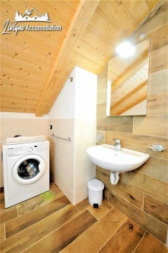 a bathroom with a washing machine and a sink at Chalet Rin Patrizia by Livigno Accomodation in Livigno