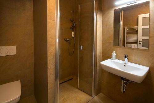 a bathroom with a sink and a shower at Penzion Panský dvůr Telč in Telč