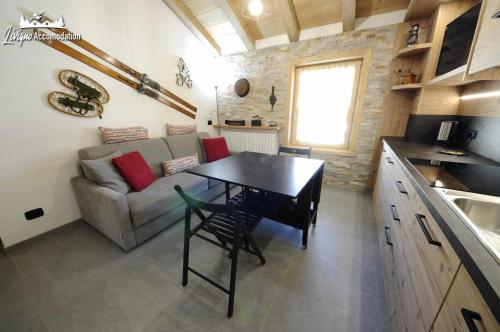 uma pequena sala de estar com uma mesa e um sofá em Baita Carosello Apt 6 Appena rinnovato em Livigno