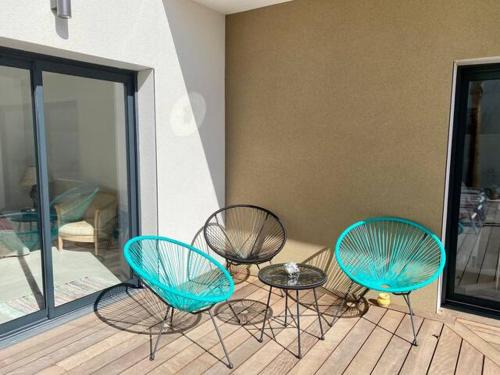 3 sillas y una mesa en el balcón en VILLA D’ARCHITECTE À 400M DE LA PLAGE, en Cap d'Agde