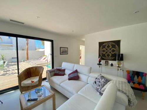 sala de estar con sofá blanco y mesa en VILLA D’ARCHITECTE À 400M DE LA PLAGE, en Cap d'Agde