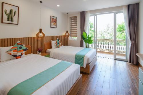 um quarto de hotel com duas camas e uma varanda em The View Hotel em Cam Lâm