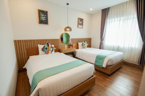 a hotel room with two beds and a window at The View Hotel in Cam Lâm