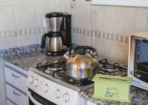 a tea kettle sitting on top of a stove in a kitchen at Cabañas Rincones del Sur in Trevelin