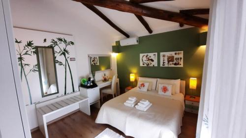 a bedroom with two white beds and a green wall at Villa Kuky in Santa Teresa Gallura
