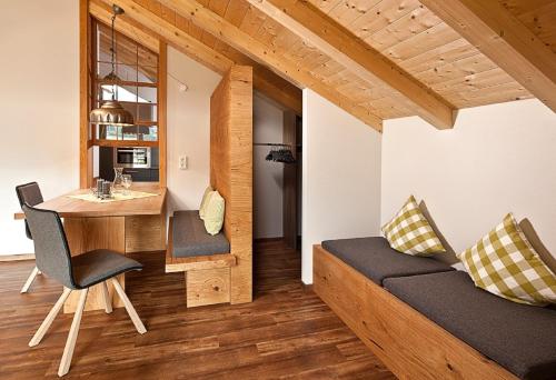 a room with a table and a couch and a desk at ALPENHAUS Steiner - Ferienwohnungen direkt am Skilift in Bolsterlang