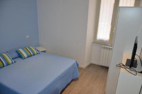 - une chambre avec un lit bleu et une télévision dans l'établissement Un Caffè sul Balcone 2, à Rome