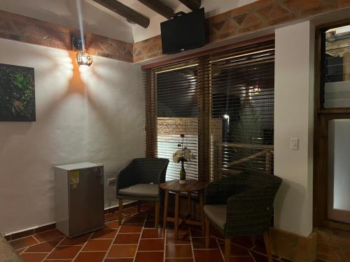 a room with a table and chairs and a window at Hotel, Bungalows, Chalet y Cabañas Aventura Park Villa De Leyva La Periquera in Villa de Leyva