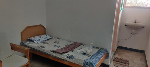ein kleines Schlafzimmer mit einem kleinen Bett und einem Waschbecken in der Unterkunft Daya Dharma residency in Tiruvannāmalai