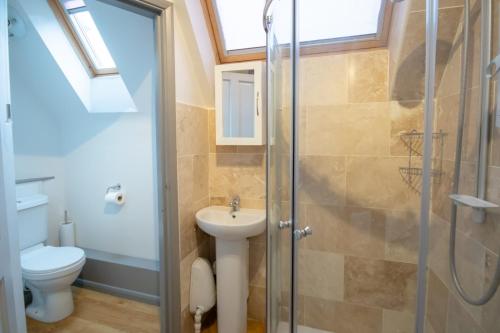 a bathroom with a shower and a sink and a toilet at Church View - Norfolk Cottage Agency in Burnham Market