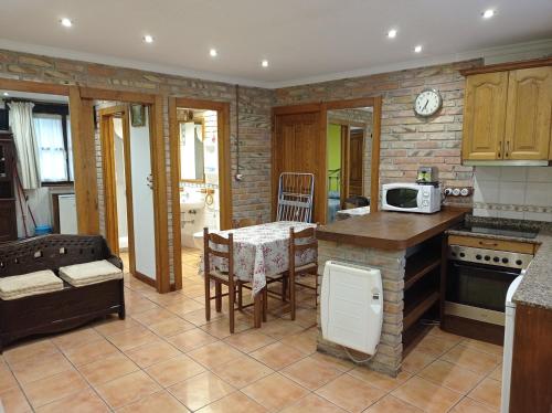 a kitchen with a table and a dining room at Apartamentos Begoña in Llanes