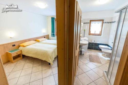 Un dormitorio con una cama y un baño. en Baita Epi Cusini by Livigno Accomodation, en Livigno