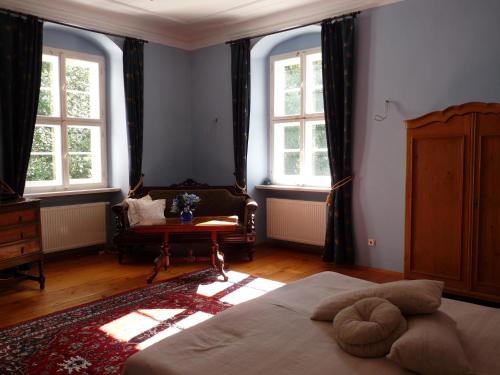 a bedroom with a bed and a chair and windows at Schloss Triestewitz in Arzberg