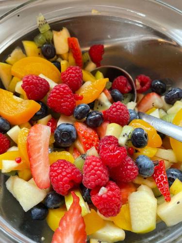 a bowl of fruit salad with a spoon in it at Hotel Lis in Asti