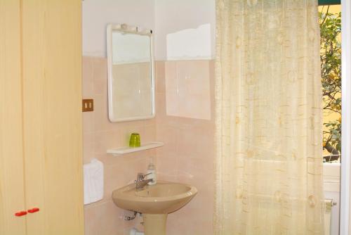 a bathroom with a sink and a mirror at HOTEL LA MADUNINA in Varazze