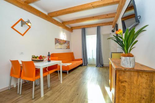 een woonkamer met een tafel en oranje stoelen bij Casa nel Borgo - Il Picchio in Tremosine Sul Garda
