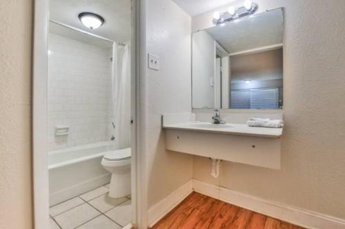 a bathroom with a sink and a toilet and a mirror at Economy Hotel Minot in Minot