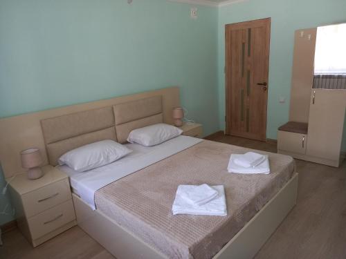 a bedroom with a bed with two towels on it at H.A.S.K in Gyumri