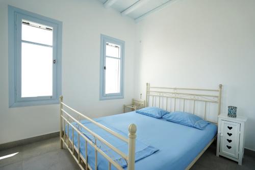 1 dormitorio con 1 cama y 2 ventanas en Serifos cozy home with a view, en Livadakia