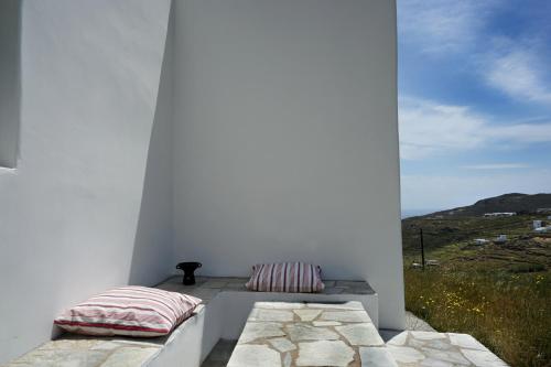 a white room with two pillows on a balcony at Serifos cozy home with a view in Livadakia