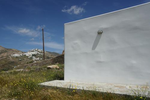a white wall with a car on top of a field at Serifos cozy home with a view in Livadakia