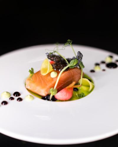 a plate of food with fish and fruit on it at Salio Equisport Resort in Stryków
