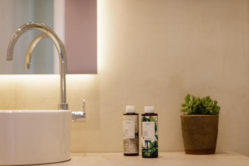 two bottles ofodorizers sitting on a counter next to a sink at SpilGaia in Spílion