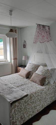 a bedroom with a large white bed with two pillows at La maison de Céline in Arry