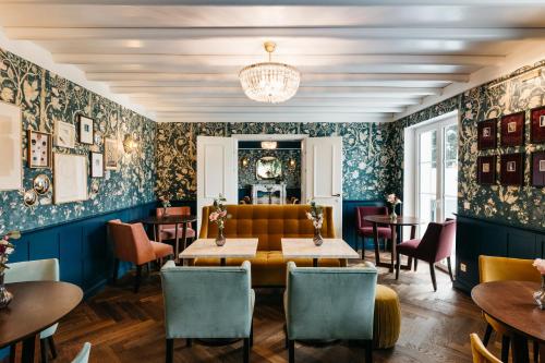 a restaurant with blue walls and tables and chairs at Numa Salzburg Ivy in Anif
