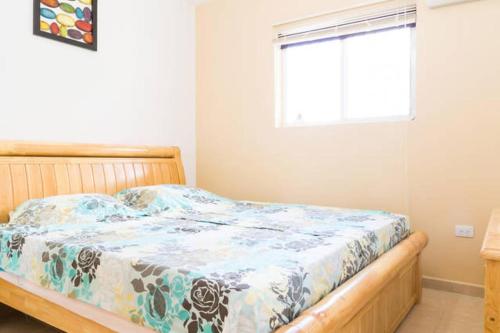 a bedroom with a bed with a blue and white blanket at Cozy home under the Sun with Swimmingpool in Paradera