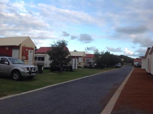 a street with houses and a car parked on the side of a road at Seaspray Beach Holiday Park in Dongara