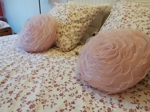 two pink pillows sitting on top of a bed at La maison de Céline in Arry