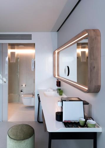 a bathroom with a sink and a laptop on a counter at b'mine Hotel Frankfurt Airport in Frankfurt/Main